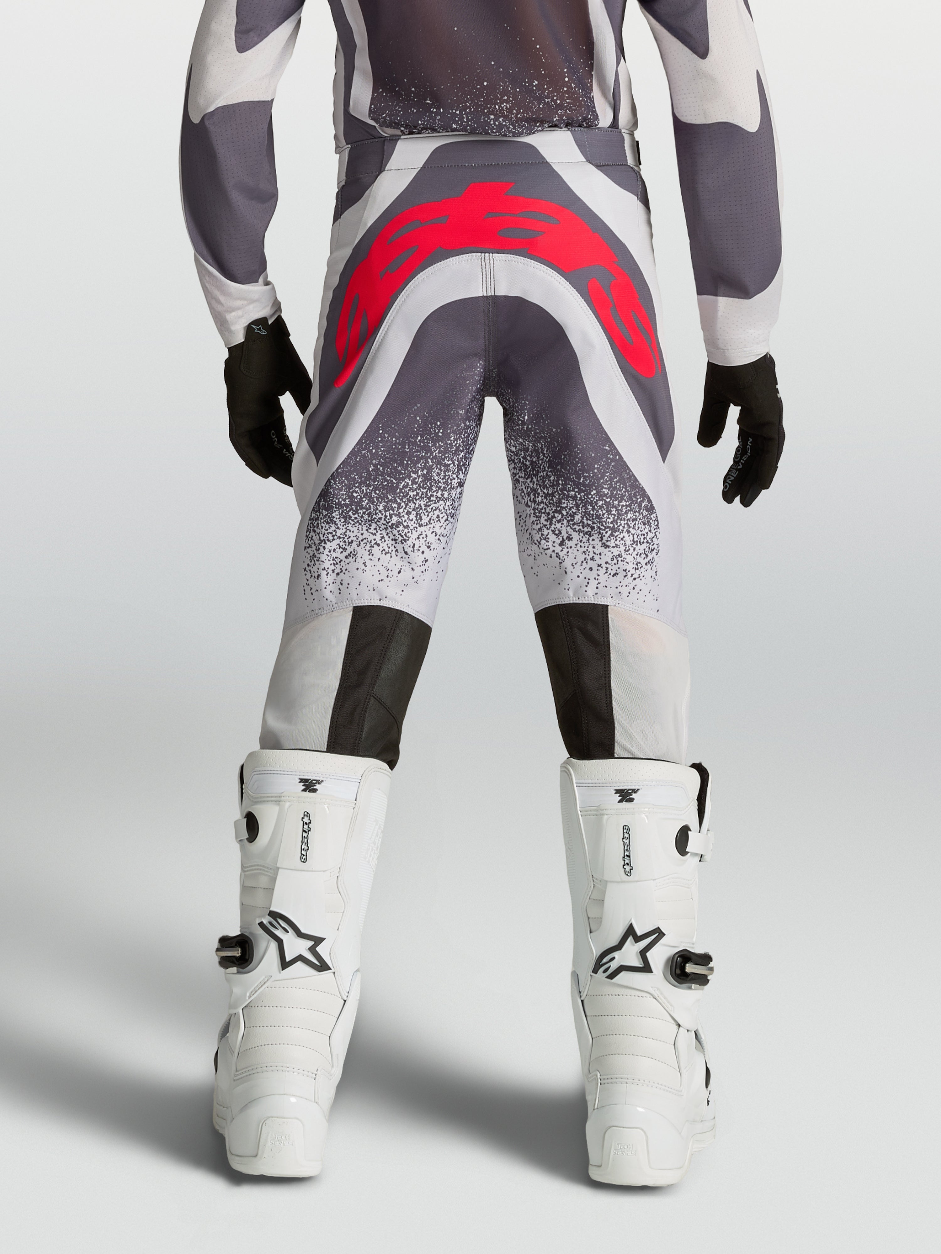 Alpinestars Supertech Swan motocrossbukser til unge, grå og rød, set bagfra med atletisk pasform og forstærket sæde.