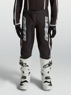 Alpinestars Youth Fluid Apex V2 Motocross Pants, Black and Silver, durable 600D polyfabric with ergonomic pre-curved legs.