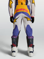 Alpinestars 2027 Fluid Drag bukser til ungdom, blå og guld motocross-bukser med stjerne-grafik, set bagfra.