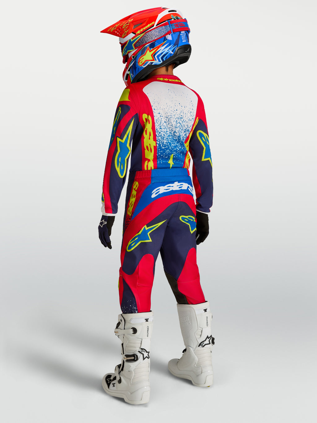 Alpinestars Fluid Drag motocrossbukser til ungdom, navyblå og røde med forstærket sæde og hvide racingstøvler.