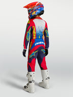 Alpinestars Fluid Drag motocrossbukser til ungdom, navyblå og røde med forstærket sæde og hvide racingstøvler.