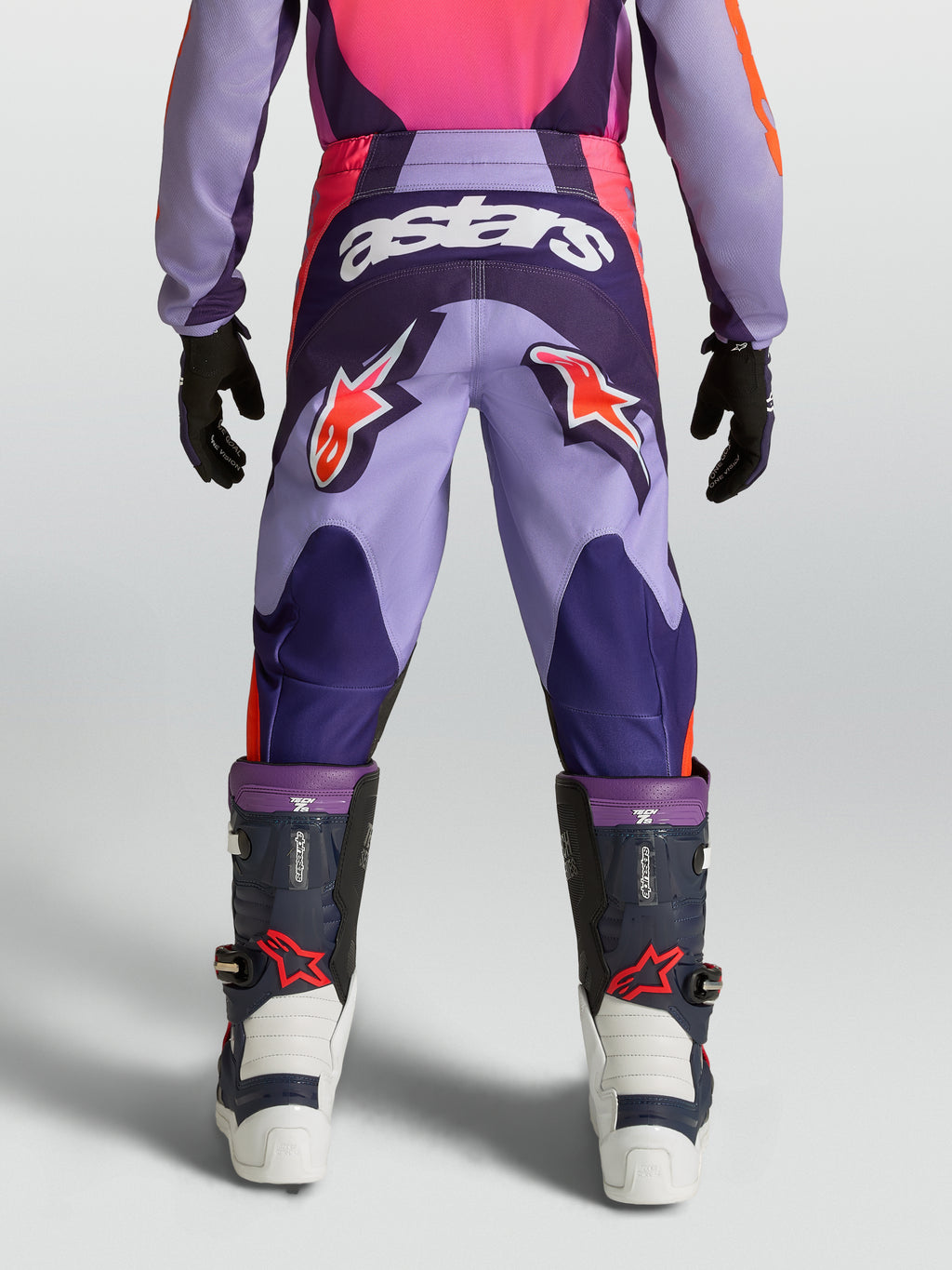 Alpinestars Youth Fluid Hunt Pants, purple and pink motocross racing gear with star logos and durable textile construction.