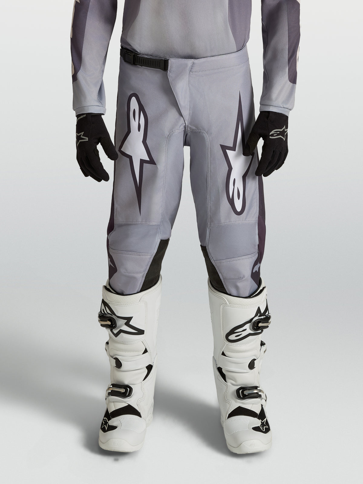 Alpinestars Youth Fluid Amber Pants, durable grey and black motocross pants for young riders in an off-road setting.
