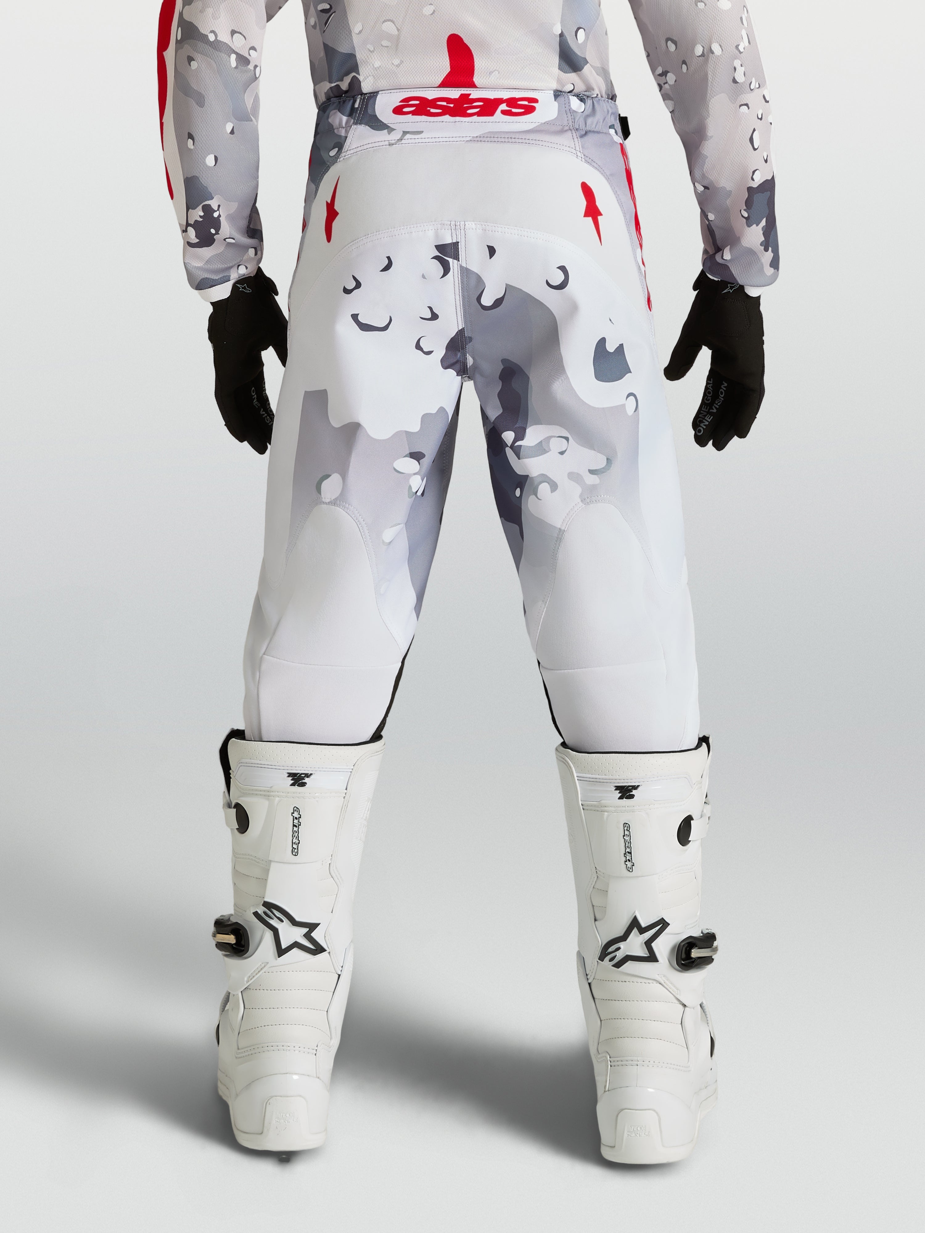 Alpinestars 2027 Fluid Lone Bukser Ungdom, grå camo og hvide motocrossbukser med røde detaljer, set bagfra på kører.