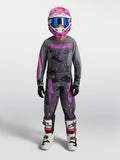 Alpinestars 2027 Ungdom Fluid Lone Gear Set, motocrossudstyr i grå og pink camouflage med trøje, bukser og hjelm.