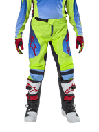 Alpinestars Youth 2024 Racer Hoen bukser, motocross-bukser, neon-gul og mørkeblå, med røde stjernelogoer på lårene, båret med matchende trøje, røde og sorte handsker samt hvide, sorte og røde motocross-støvler, holdbart udstyr til terrænkørsel
