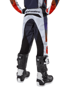 Alpinestars 2024 Youth Racer Hoen bukser, motocrossbukser til unge, lysegrå med stærk orange og sorte detaljer, set bagfra med sorte paneler på sædet og benene, markant branding på bagtaljen, båret med sort-hvide motocrossstøvler til terrænkørsel
