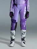 Alpinestars 2026 Stella Fluid Apex bukser til damer, motocross-bukser, violet og hvid, båret med sorte og violette handsker og hvide og sorte støvler, med markant hvid branding på benet, ergonomisk sport-fit design til off-road racing
