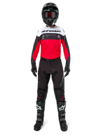 Motocrossrytter iført Alpinestars Pro-Dura Jersey i sort, klar rød og hvid, kombineret med sorte bukser, sorte støvler og en sort hjelm, komplet off-road racerudstyr.