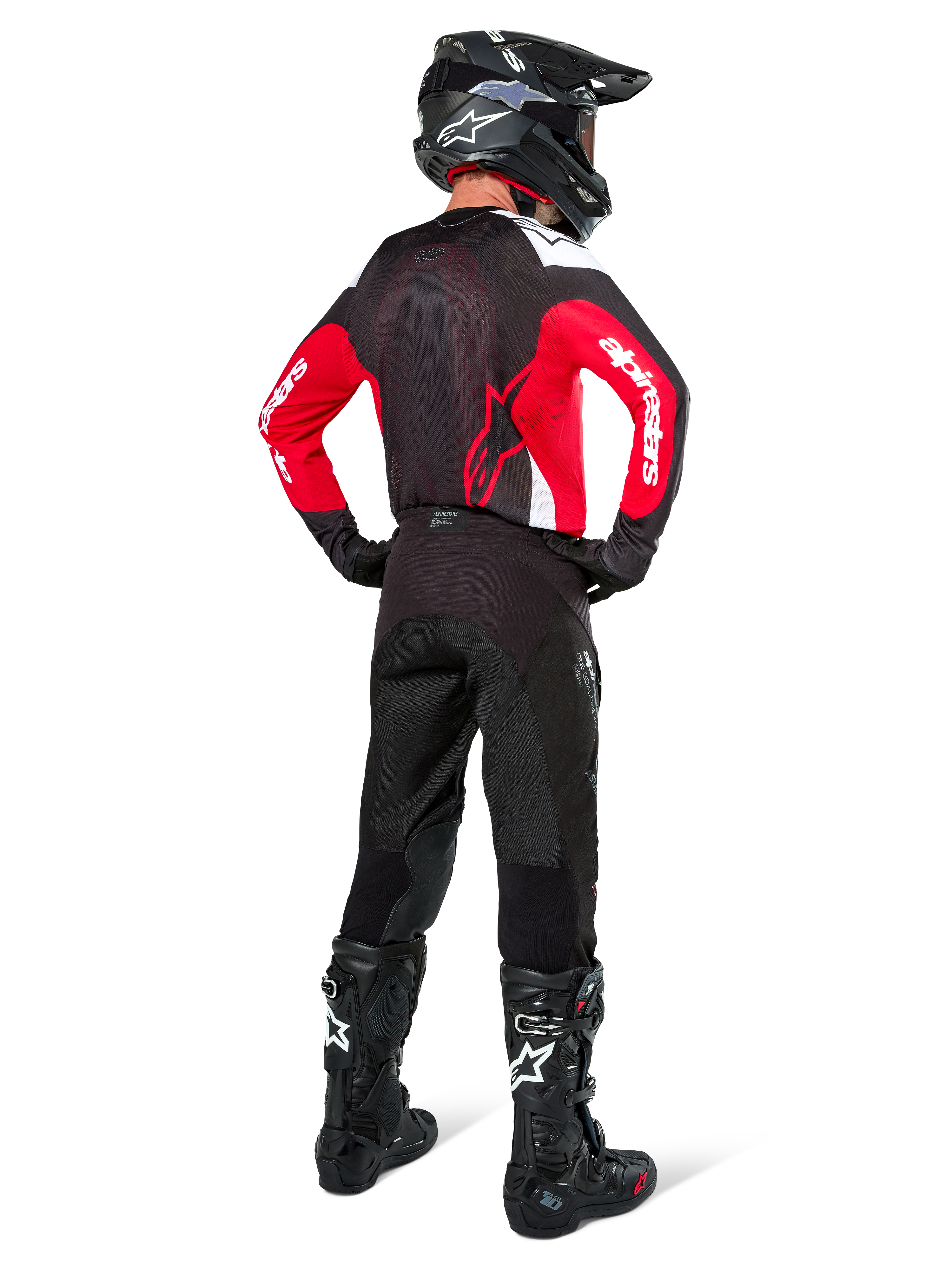 Motocrosskører set bagfra iført Alpinestars Pro-Dura trøje i sort, kraftig rød og hvid, kombineret med sorte motocrossbukser, hjelm og støvler, viser designet bagpå og logoer på ærmerne, koordineret off-road racerudstyr.