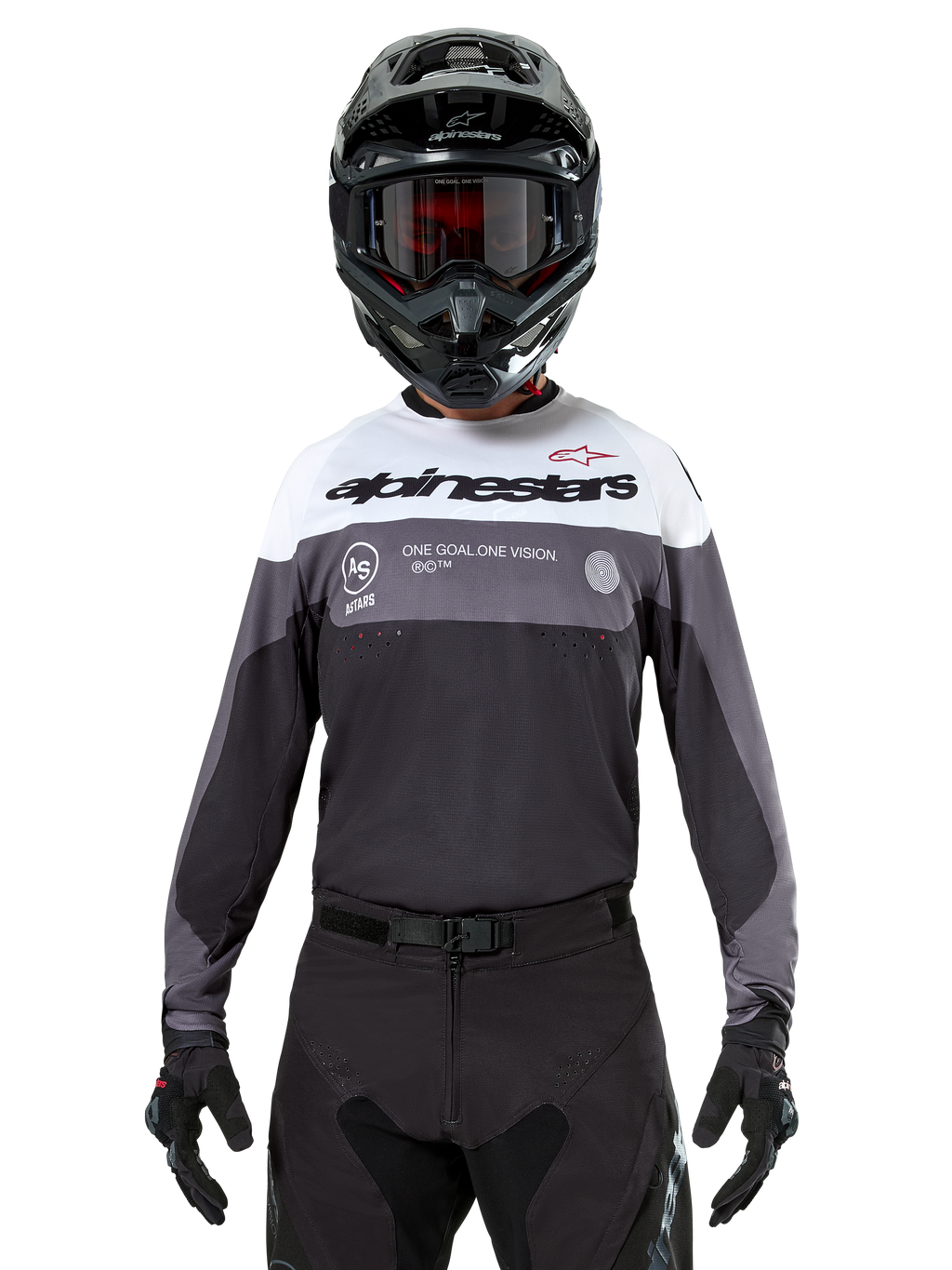 Motocross-rytter iført Alpinestars Pro-Dura Jersey i Black Magnet White, langærmet performance-trøje med hvide og grå farveblokke, bæres med sort hjelm og goggles, med 'alpinestars' branding og 'ONE GOAL ONE VISION' slogan, off-road motorcykel-racingudstyr