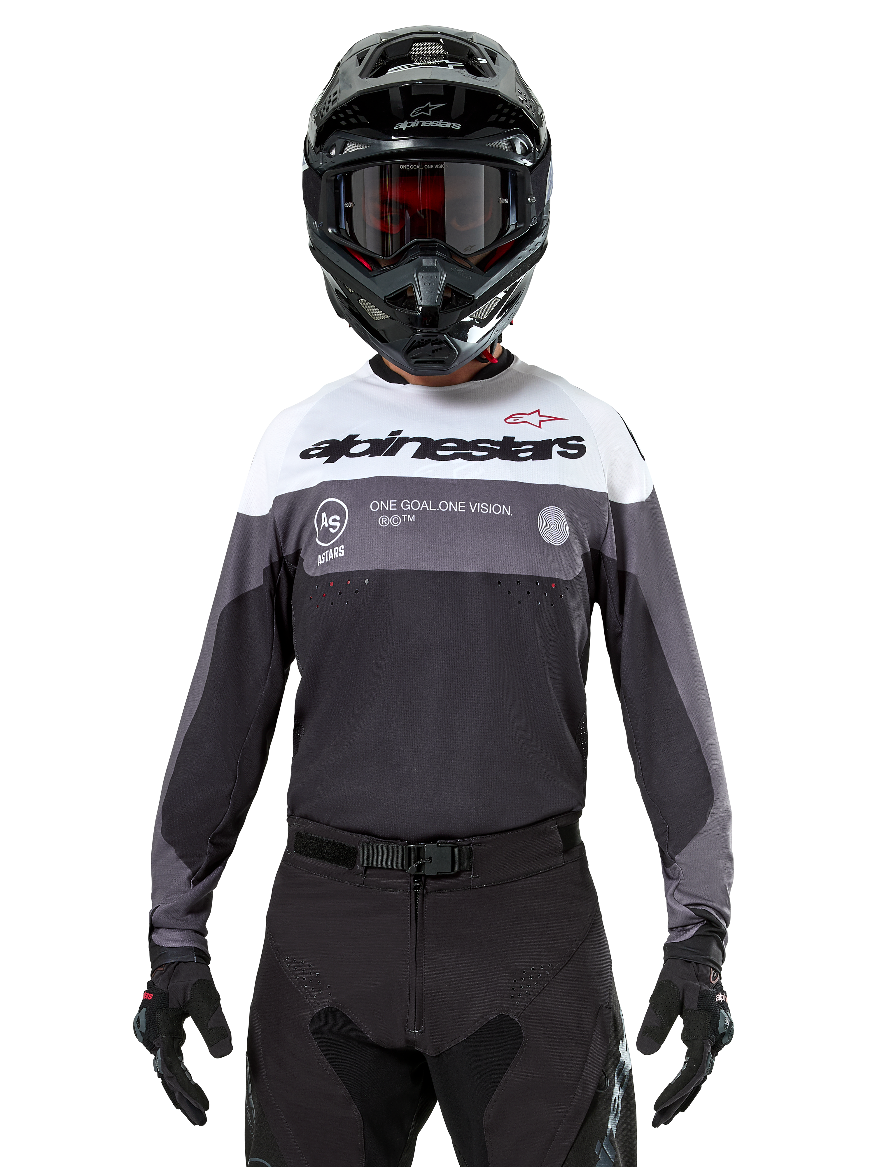 Motocross-rytter iført Alpinestars Pro-Dura Jersey i Black Magnet White, langærmet performance-trøje med hvide og grå farveblokke, bæres med sort hjelm og goggles, med 'alpinestars' branding og 'ONE GOAL ONE VISION' slogan, off-road motorcykel-racingudstyr