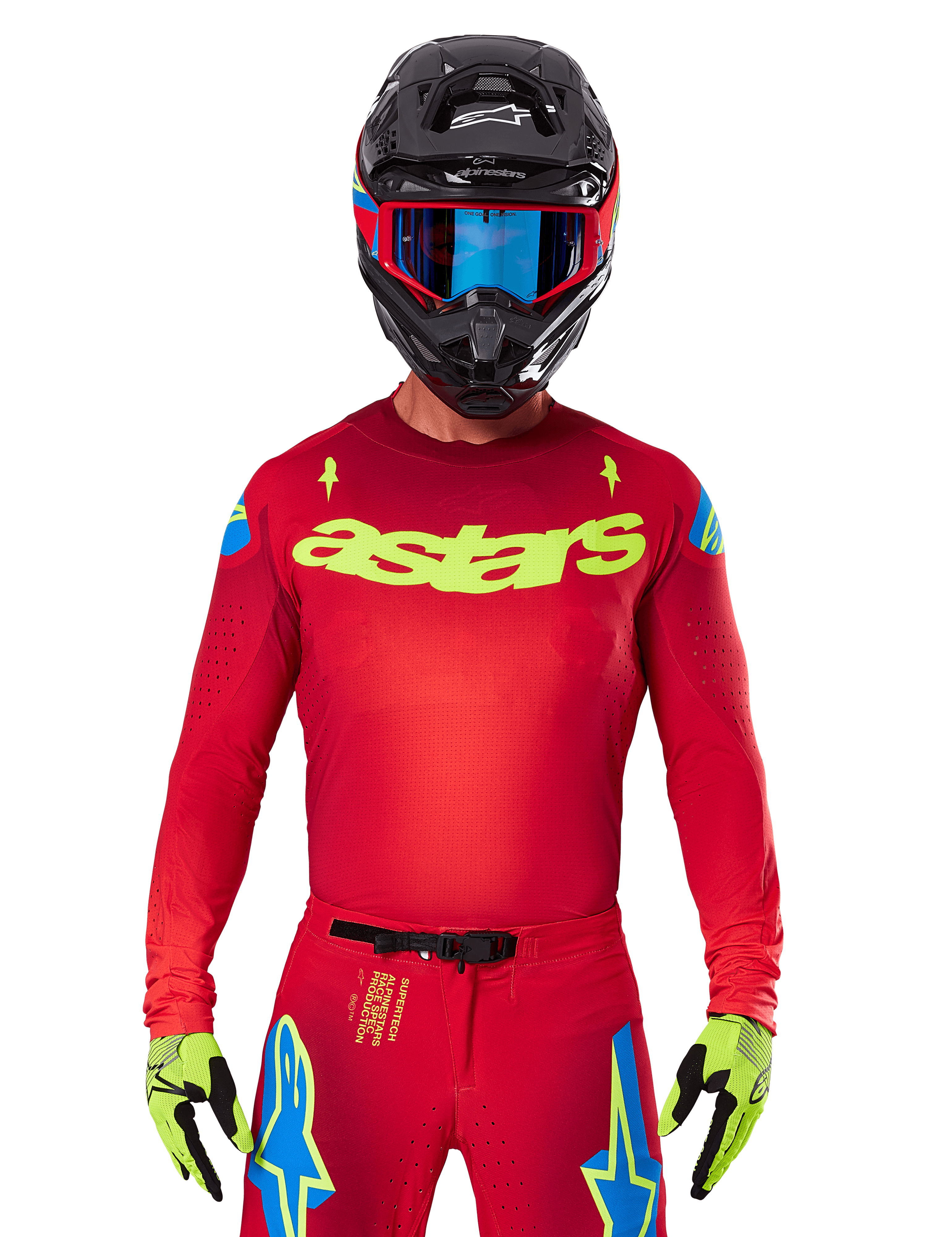 Alpinestars 2025 Supertech Maker Jersey i Bright Red Yellow Fluo, med gult 'astars' brystlogo og blå stjernedesigns på skuldrene, båret med matchende bukser, sort hjelm, blå goggles og gule handsker, professionelt motocross-racerudstyr