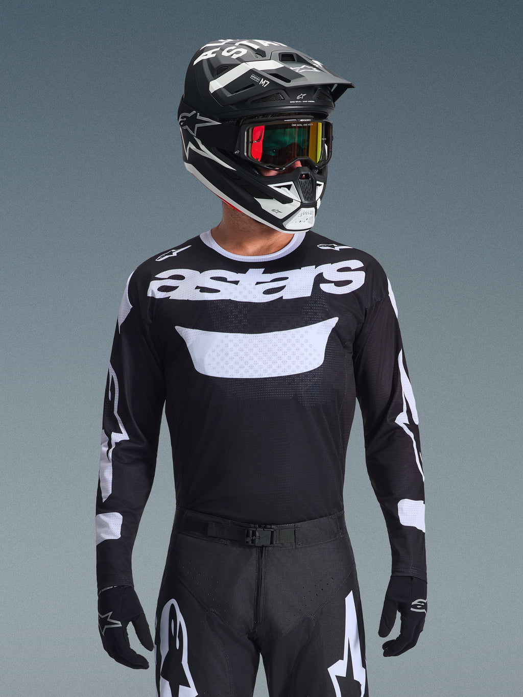 Alpinestars 2026 Racer Air Riway jersey, sort og hvid motocross-trøje med 'astars'-branding, båret af en kører med matchende sort hjelm, goggles og bukser, med åndbare mesh-paneler til off-road racing.