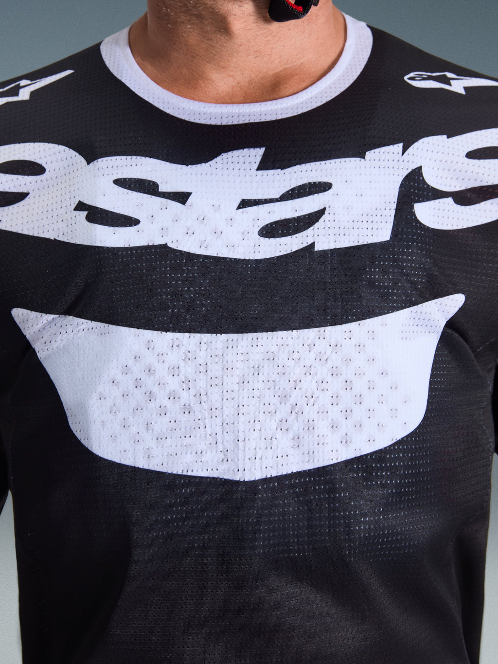 Alpinestars 2026 Racer Air Riway jersey, motocross-trøje, sort og hvid, nærbillede af bryst med stort hvidt logo, detaljeret mesh-tekstur for luftgennemstrømning, teknisk åndbart udstyr til off-road kørsel