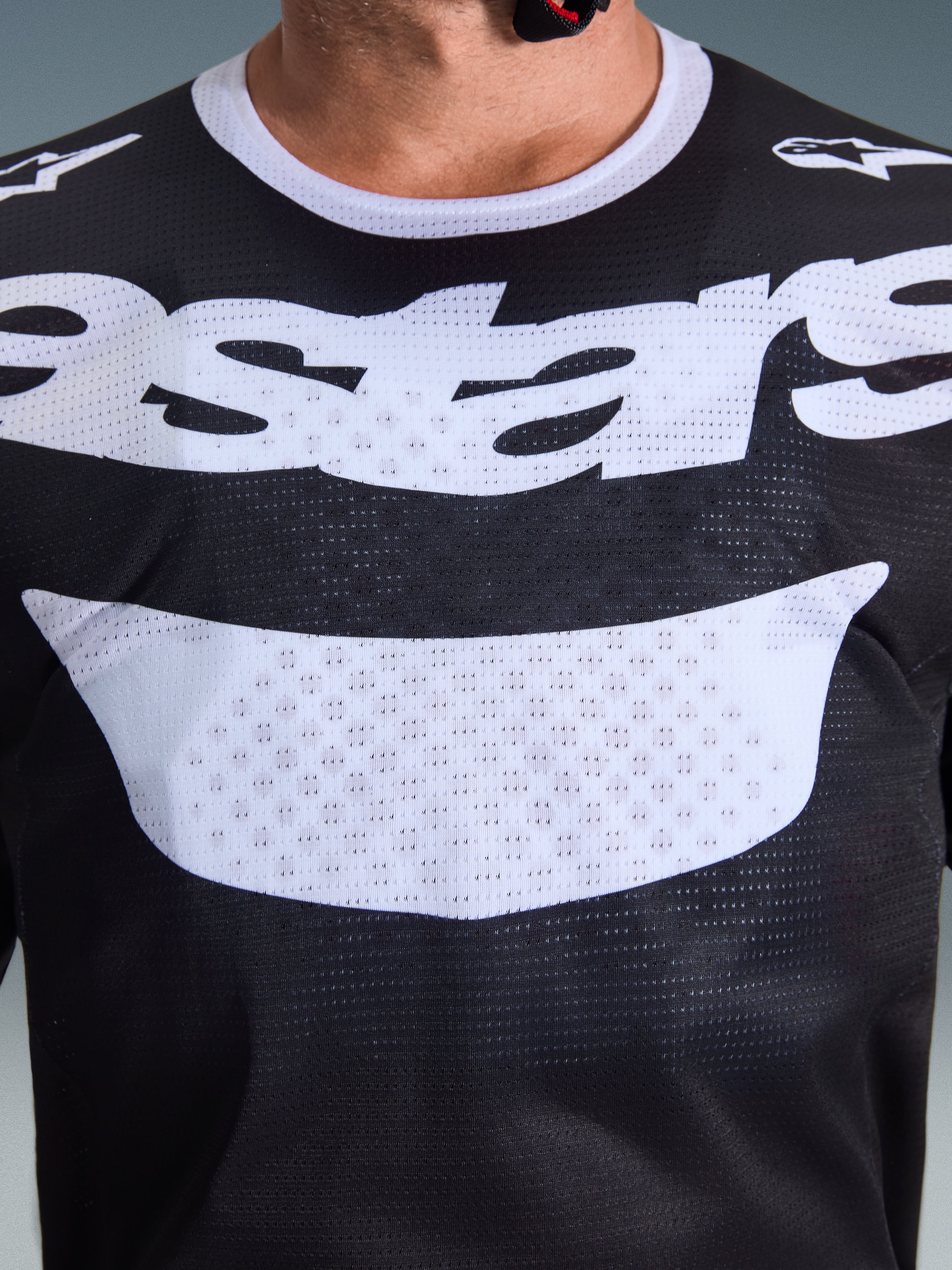 Alpinestars 2026 Racer Air Riway jersey, motocross-trøje, sort og hvid, nærbillede af bryst med stort hvidt logo, detaljeret mesh-tekstur for luftgennemstrømning, teknisk åndbart udstyr til off-road kørsel