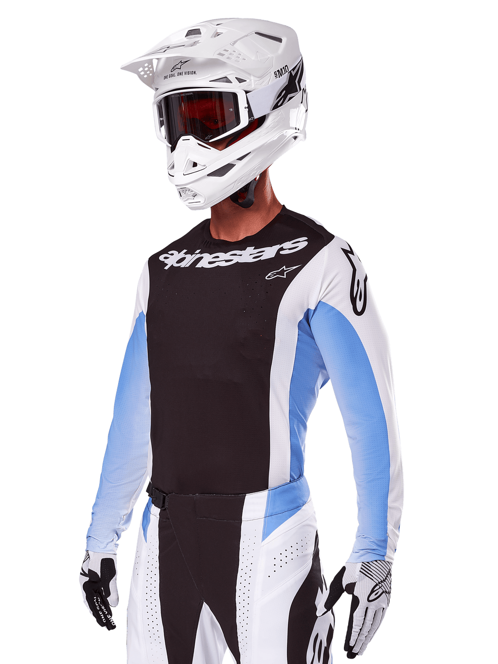Motocrossrytter iført Alpinestars 2025 Techstar Melt udstyrssæt, hvid med sorte og lyseblå detaljer, bestående af en jersey med sort bryst og hvide ærmer, matchende hvide og sorte bukser, hvid SM10-hjelm med goggles og sort-hvide handsker, komplet professionelt off-road raceroutfit.