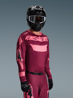 Alpinestars 2026 Racer Riway Gear Set, motocrosskører iført bordeaux og lyserød jersey med tydelig 'astars'-branding, matchende bukser med lyserøde detaljer, sort hjelm og handsker, professionelt raceroutfit til off-road motocross