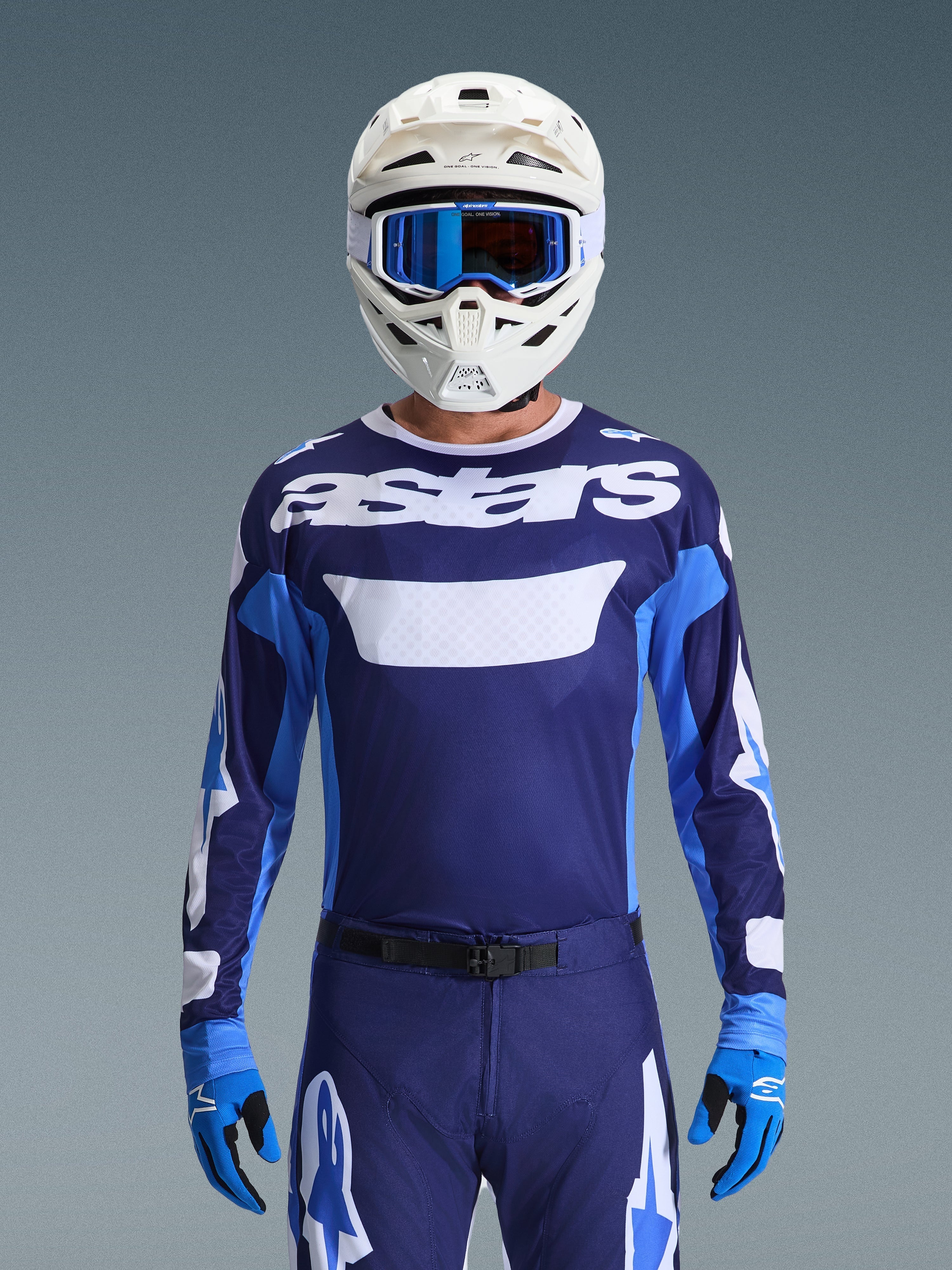 Motocrosskører iført Alpinestars 2026 Racer Riway trøje, UCLA Blue og hvid med hvidt 'astars'-logo på brystet, hvid hjelm med blå goggles, matchende motocrossbukser og blå handsker, koordineret off-road-racerudstyr