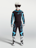 Alpinestars Supertech Vesta trøje og motocrossudstyrssæt, herre, sort og turkis med hvid hjelm og hvide støvler.
