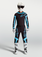 Alpinestars Supertech Vesta Jersey and Gear Set, Men's Motocross Outfit, Black and Turquoise with White Boots and Helmet.