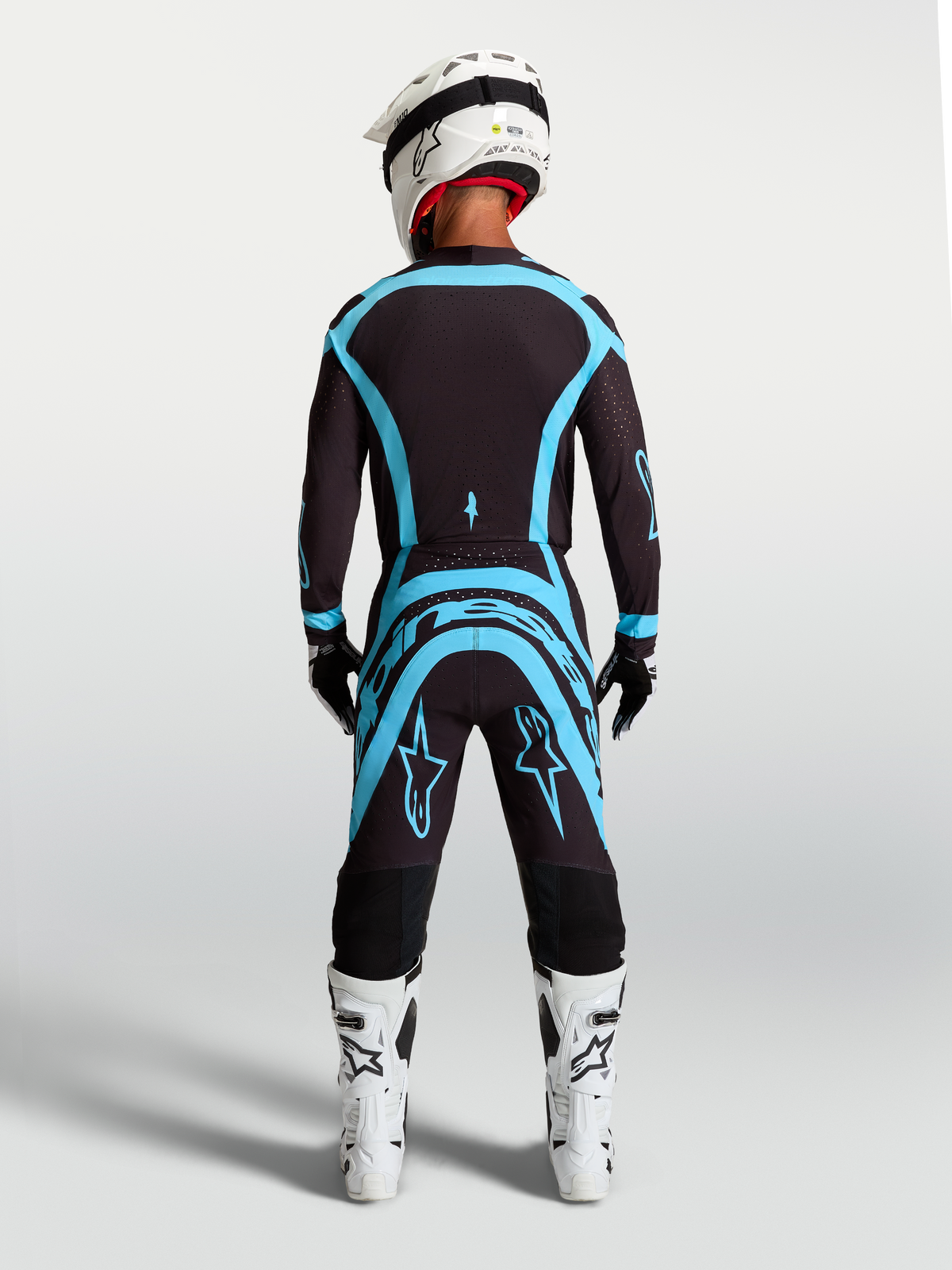 Alpinestars Supertech Vesta udstyrssæt, motocross-trøje og bukser, sort og turkis, set bagfra med atletisk pasform.