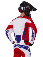 Alpinestars 2025 Racer Veil Jersey and Pants, Motocross Gear Set, Bright Red White and Blue, rear view of rider wearing matching gear and black motocross helmet, featuring bold blue Alpinestars branding, technical off-road racing apparel