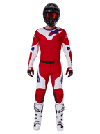 Motocross rider wearing the Alpinestars 2025 Racer Veil Gear Set, Bright Red and White jersey and pants with blue accents, black helmet with red goggles, white boots, and red and black gloves, coordinated outfit for off-road racing