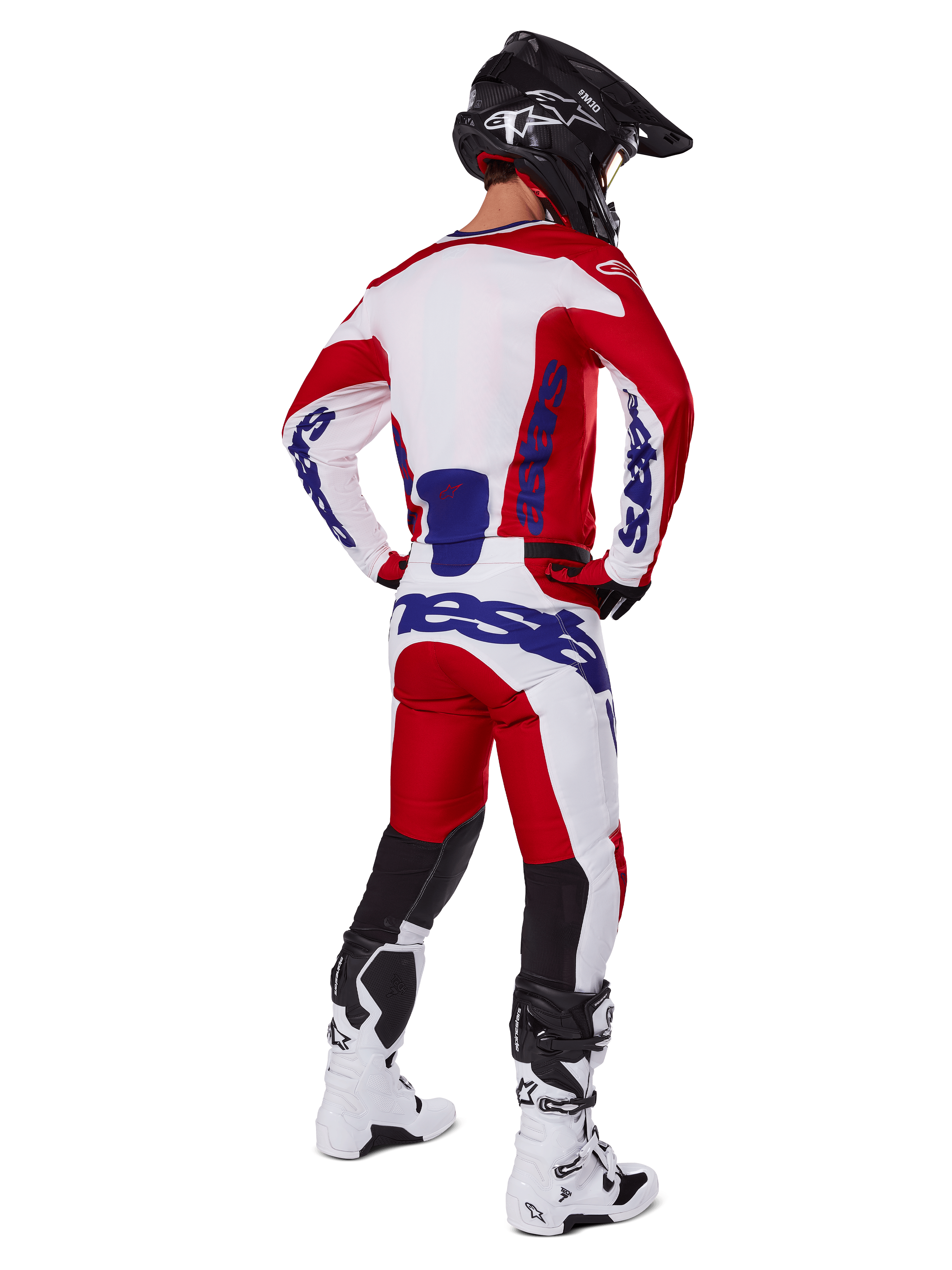 Motocross rider shown from behind wearing the Alpinestars 2025 Racer Veil Jersey and Pants in Red and White, featuring blue branding, black helmet, and white boots, complete gear set for off-road racing