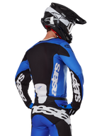 Alpinestars 2025 Racer Veil-udstyrssæt, motocross-udstyr, blå, sort og hvid, set bagfra af kører iført trøje og bukser med markant branding, sort og hvid hjelm, koordineret outfit til terrænkørsel