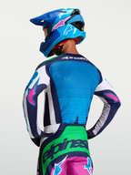 Alpinestars Techstar Maven Jersey, motocross performance riding jersey for men, vibrant blue and green with pink accents, rear view on model.