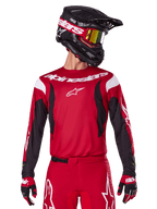 Alpinestars 2025 Fluid Haul Jersey, Motocross Jersey, Bright Red and Black, worn as part of a complete gear set with matching pants and gloves, black helmet with yellow lens goggles, white branding and logos, high-performance off-road racing apparel