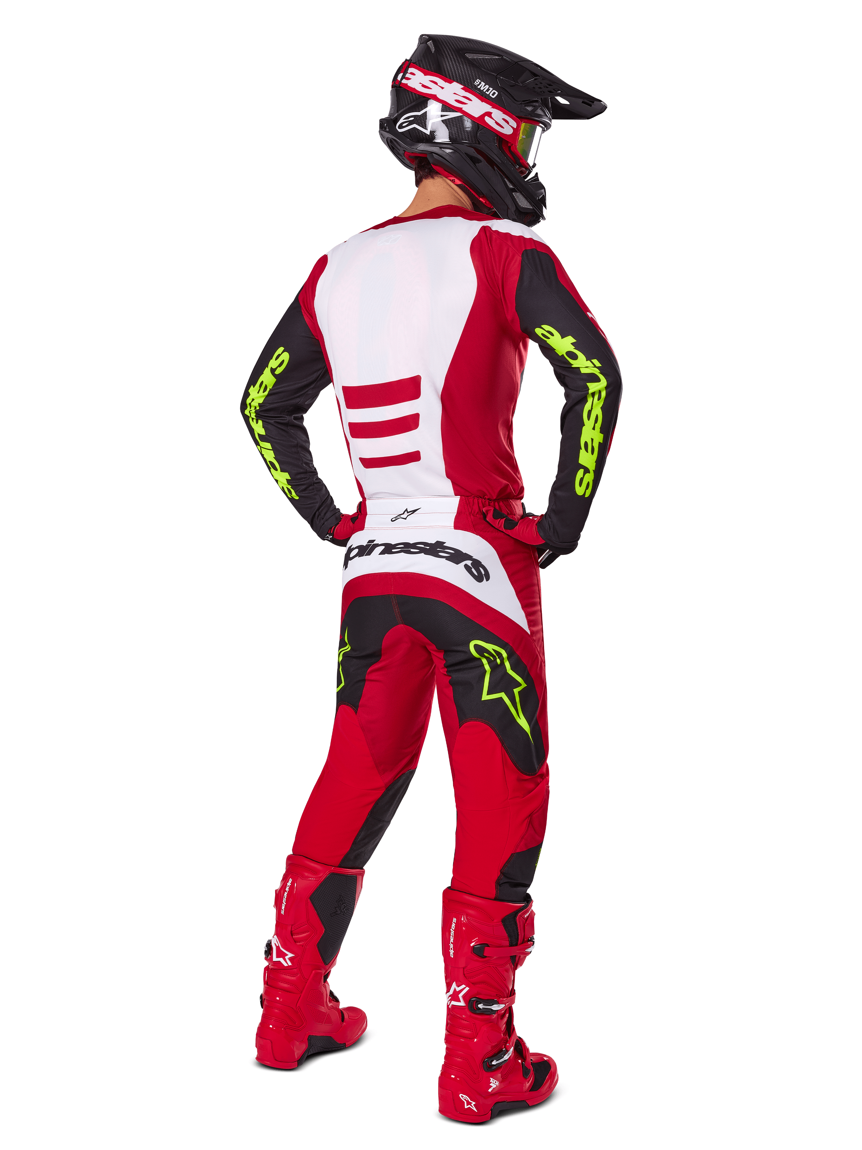 Motocross rider from behind wearing the Alpinestars 2025 Fluid Haul Gear Set, Bright Red and Black with white panels, neon yellow branding on sleeves and pants, matching red boots and black helmet, complete professional off-road racing gear.
