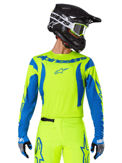 Alpinestars 2025 Fluid Haul trøje, motocross-jersey, neongul og blå, med blåt Alpinestars-logo på brystet, vist sammen med matchende udstyr inklusiv en sort hjelm og blå handsker, atletisk pasform til off-road kørsel