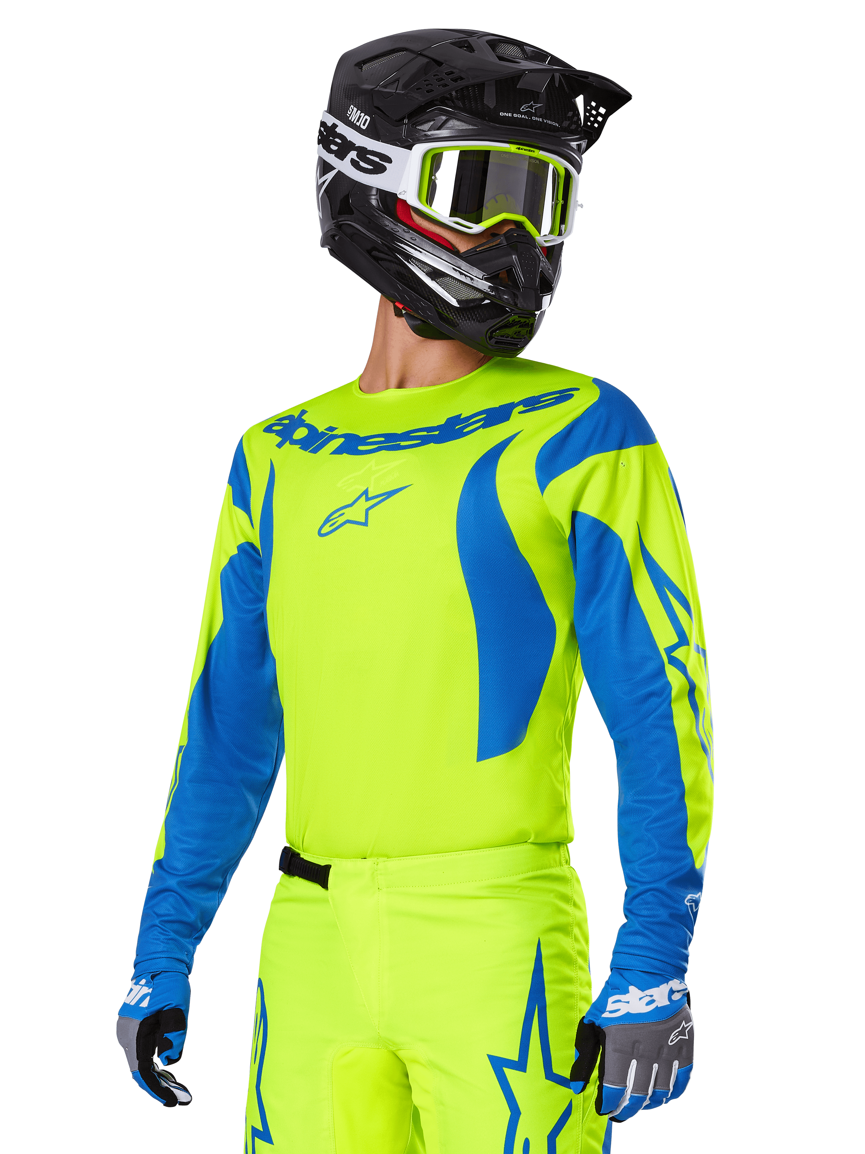 Alpinestars 2025 Fluid Haul-udstyrssæt, motocross-trøje og -bukser, klar gul og blå, båret med en sort hjelm og briller med gul ramme, har bølgeagtige blå mønstre på ærmerne og blå stjernelogoer på bukserne, koordineret off-road racing-outfit