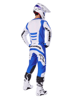 Motocross rider from the back wearing the Alpinestars 2025 Fluid Haul Gear Set, Blue and White jersey with matching pants, white helmet with blue accents, and white and black racing boots, coordinated off-road racing outfit