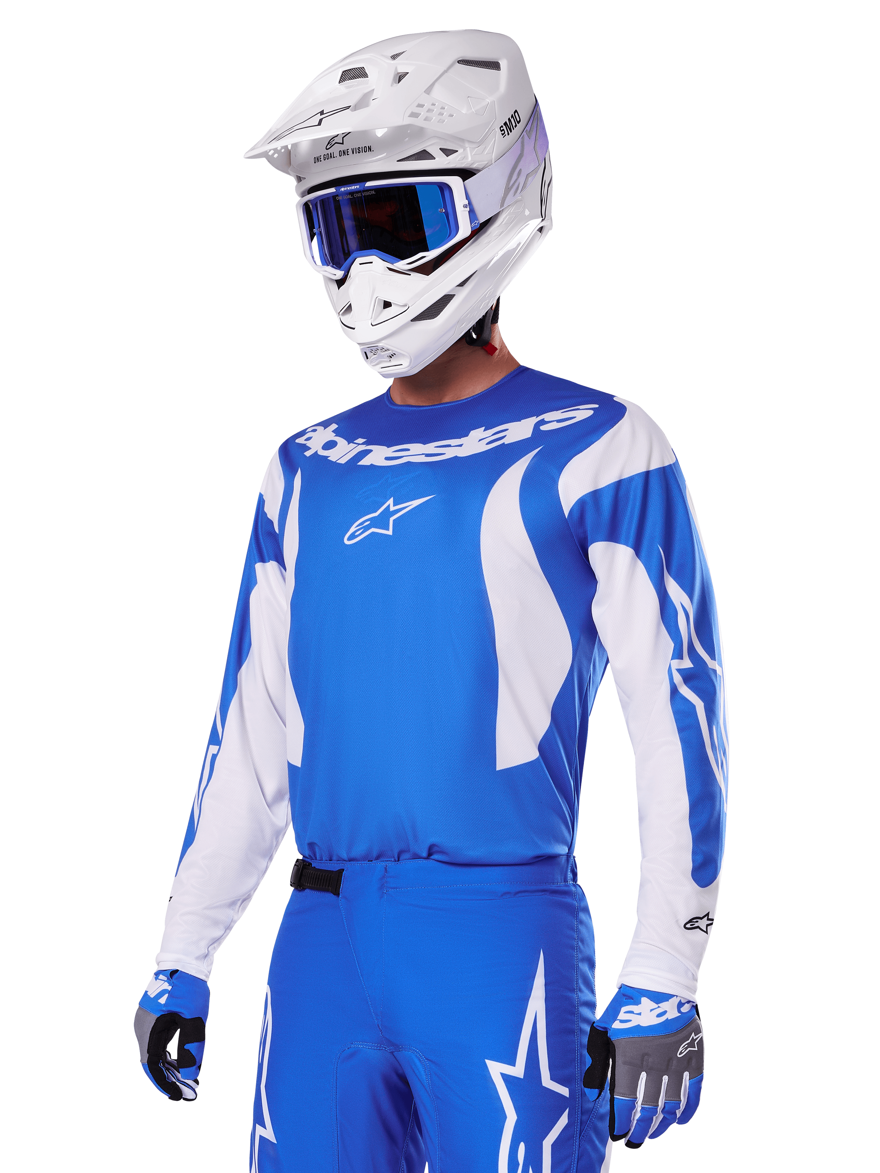 Alpinestars 2025 Fluid Haul-udstyrssæt, motocross-kører iført blåt og hvidt udstyr, blå jersey med hvide detaljer, blå bukser med stjernelogoer, hvid hjelm med blå goggles og blå og grå handsker, komplet outfit til terrænkørsel