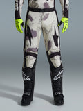 Alpinestars 2026 Racer Lahnd bukser, motocross-bukser, Sand Camo-mønster med grå og lilla abstrakt grafik, båret med neongule handsker og sorte støvler, med sorte stjernelogoer på lårene og et sort taljebælte, slidstærkt off-road racingudstyr