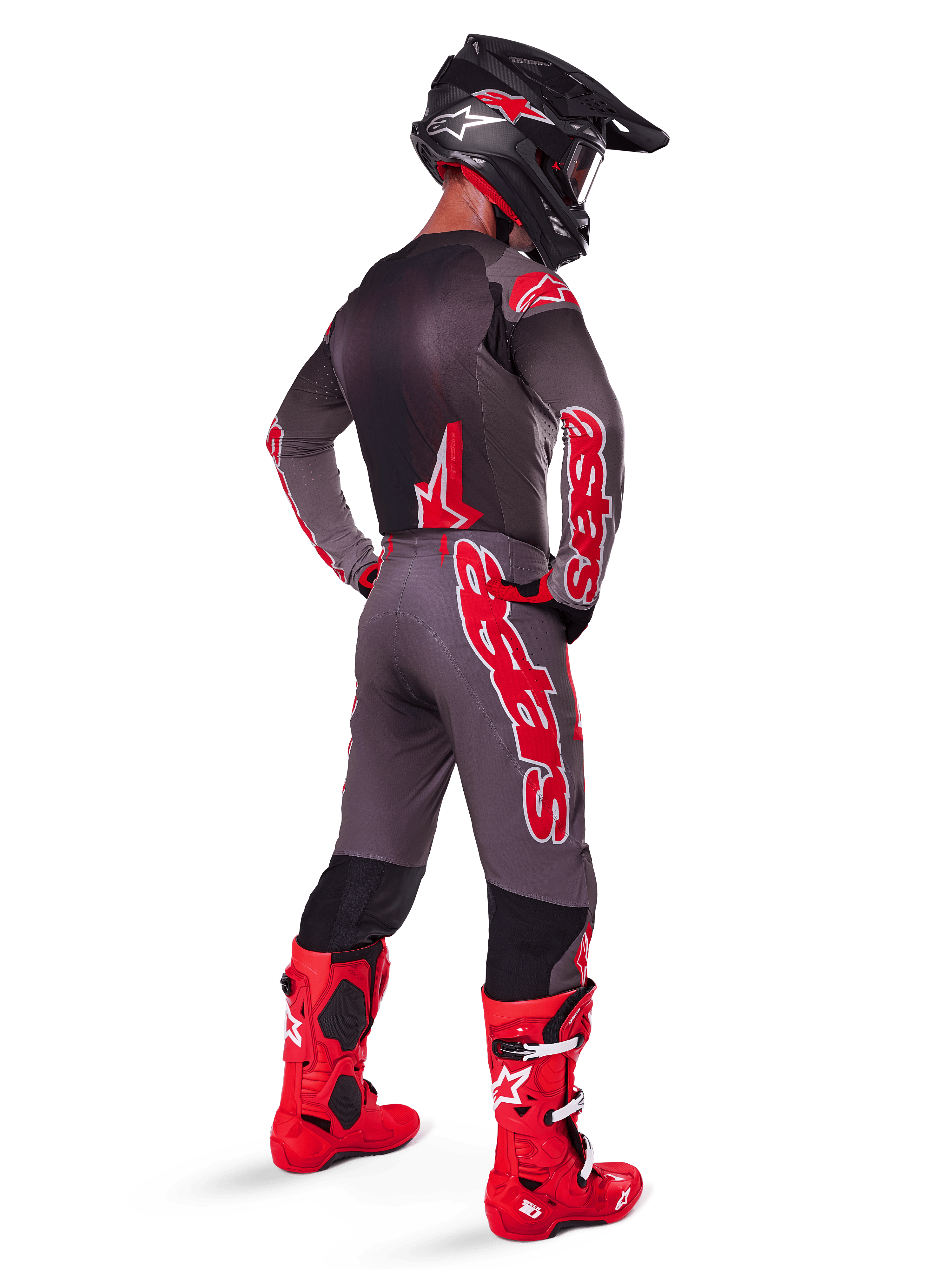 Alpinestars 2025 Supertech Lipan-udstyrssæt, motocrosskører set bagfra i farven Smoke Bright Red, grå trøje og matchende bukser med rød Alpinestars-branding, klare røde racestøvler og sort hjelm med røde logoer, komplet professionelt racersæt til terrænkørsel