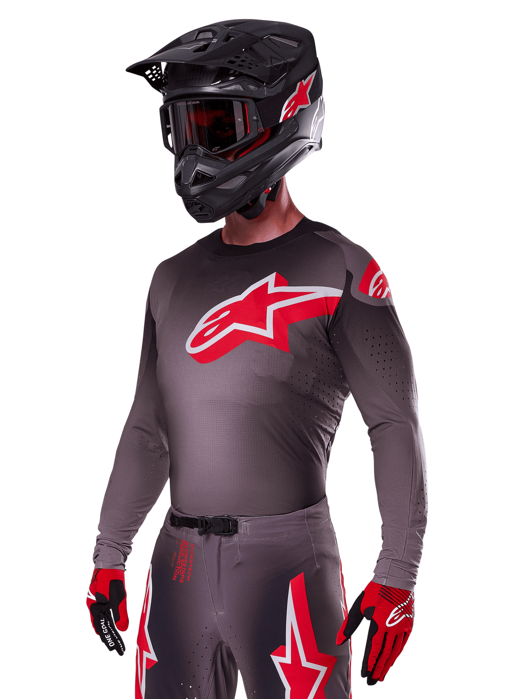 Alpinestars 2025 Supertech Lipan Gear Set, motocross-kører iført mørkegrå trøje og bukser med røde og hvide detaljer, stort rødt Alpinestars-logo på brystet, laserskårne perforeringer til ventilation, matchende sort hjelm, røde goggles og rød-sorte handsker.