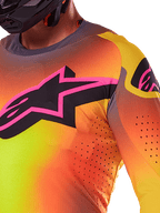 Close-up of the Alpinestars 2025 Supertech Lipan Jersey in Yellow Pink, featuring a vibrant gradient design, a large black star logo with a pink border on the chest, and visible laser-cut perforations for enhanced airflow.