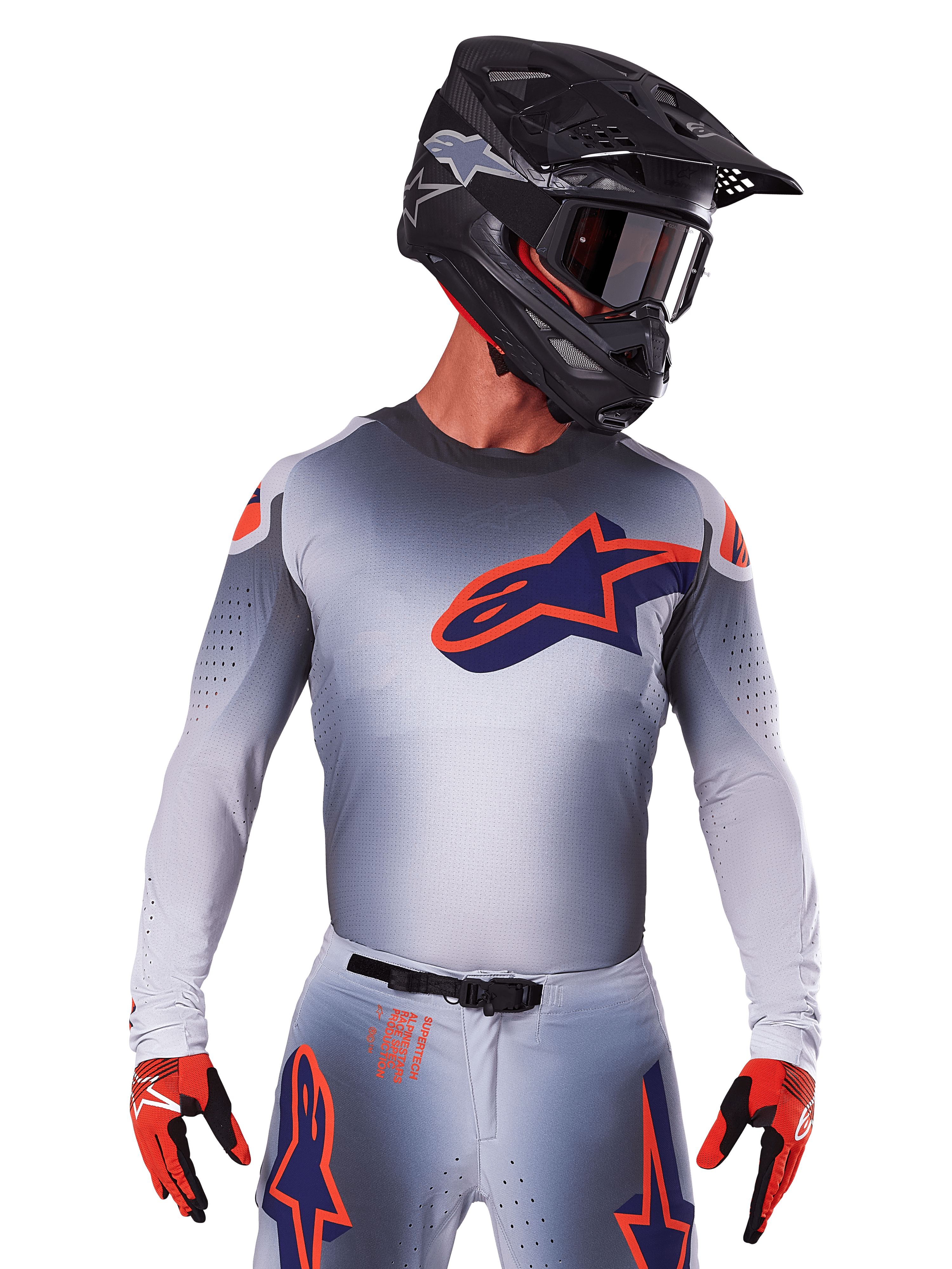 Alpinestars 2025 Supertech Lipan Jersey, motocross racertrøje, grå med orange og mørkeblå detaljer, langærmet performance-top med perforerede ventilationsdetaljer, vist med sort hjelm og røde handsker, strømlinet racerdesign