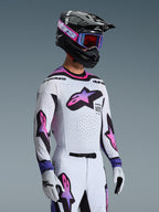 Motocrosskører iført 2026 Supertech AFD Vista-trøje i White Purple Black, matchende hvide og lilla bukser, sort hjelm med lilla goggles og hvide handsker, komplet professionelt off-road raceroutfit.