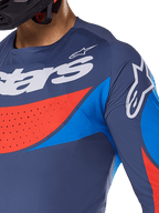 Nærbillede af Alpinestars 2025 Techstar Dreem Jersey, marineblå med klare blå og orange detaljer, hvid Alpinestars-branding på bryst og skulder, med laserskårne perforeringer til ventilation