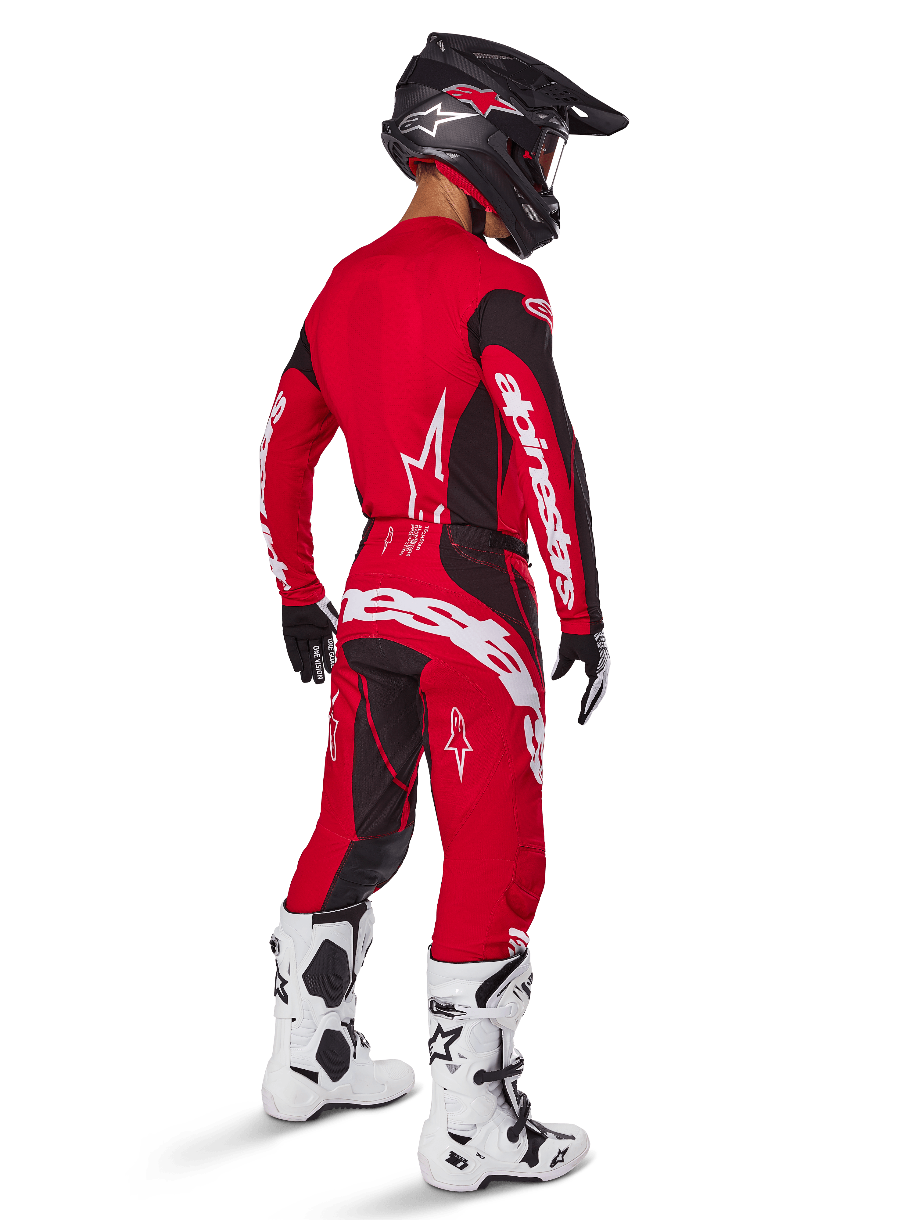 Motocrosskører iført Alpinestars 2025 Techstar Dreem-udstyrssæt i klar rød og sort, med hvid branding på trøje og bukser, kombineret med en sort hjelm, hvide og sorte støvler samt sort-hvide handsker, set skråt bagfra.