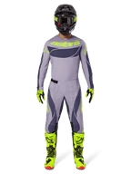Motocross-rytter iført fuldt racerudstyr, 2025 Techstar Dreem trøje i grå og mørkegrå med neongul branding, matchende grå og mørkegrå bukser, neongule og sorte støvler, sort hjelm med neon-detaljer, koordineret outfit til professionel motocross
