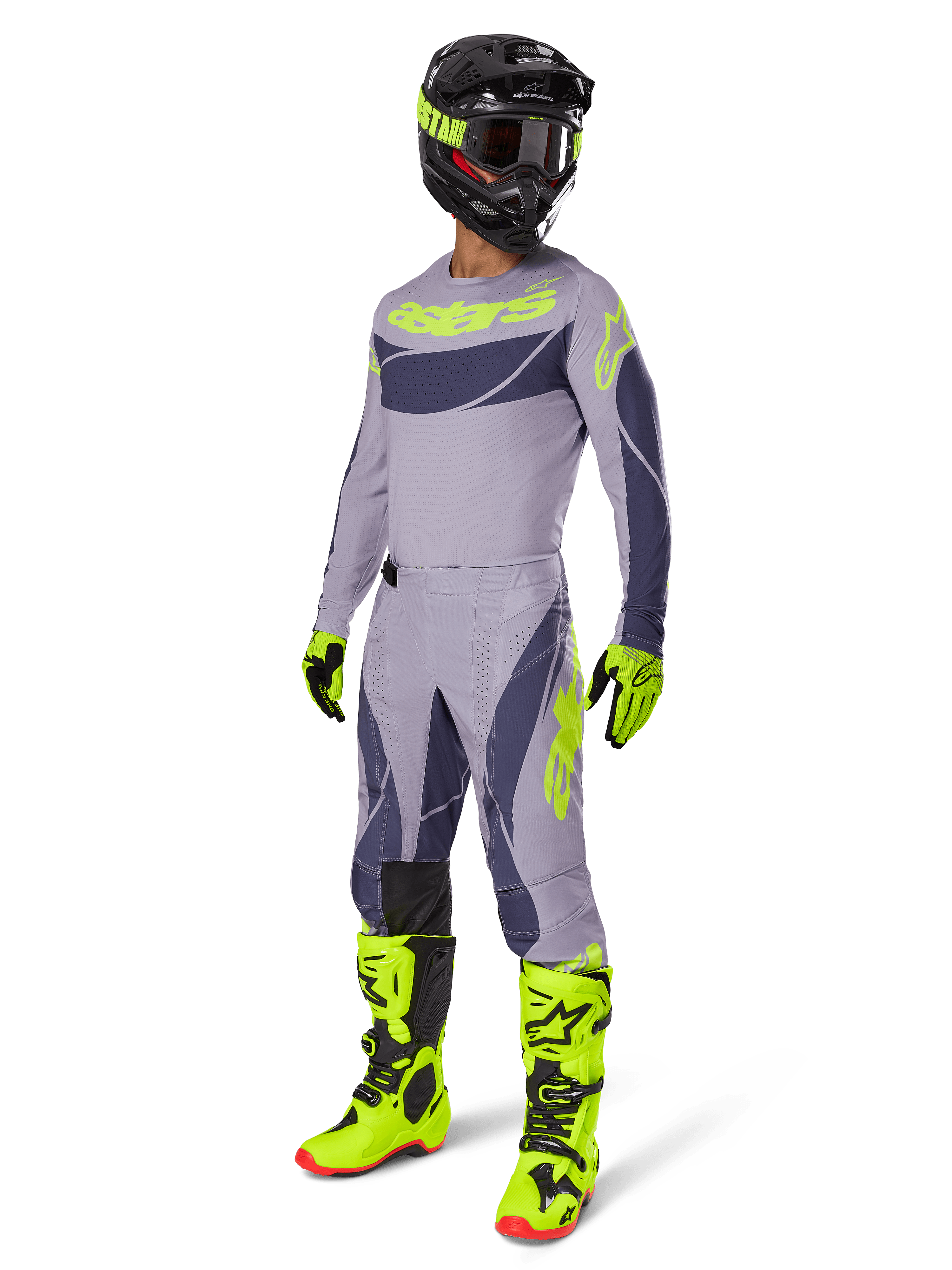 Alpinestars 2025 Techstar Dreem-udstyrssæt, motocross-kører i fuldt raceroutfit, grå jersey og bukser med mørkegrå mønstre og neongule-grønne detaljer, matchende sort hjelm, neongule-grønne handsker og støvler, performance-udstyr til terrænkørsel