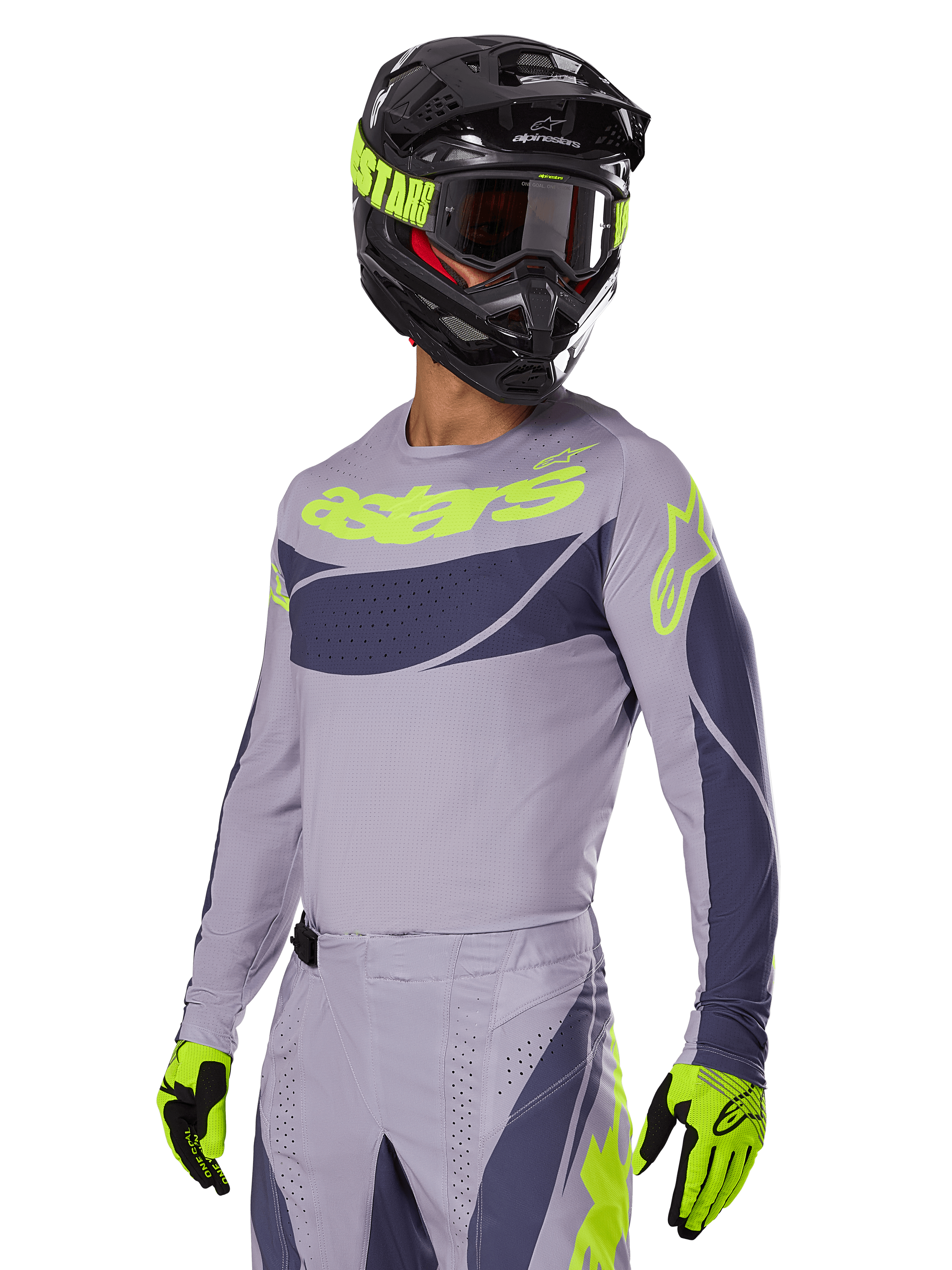 Motocross-kører iført Alpinestars 2025 Techstar Dreem Jersey i grå og mørkegrå, med et neongult 'astars' logo på brystet, kombineret med en matchende hjelm, goggles og handsker for et koordineret off-road racing-look