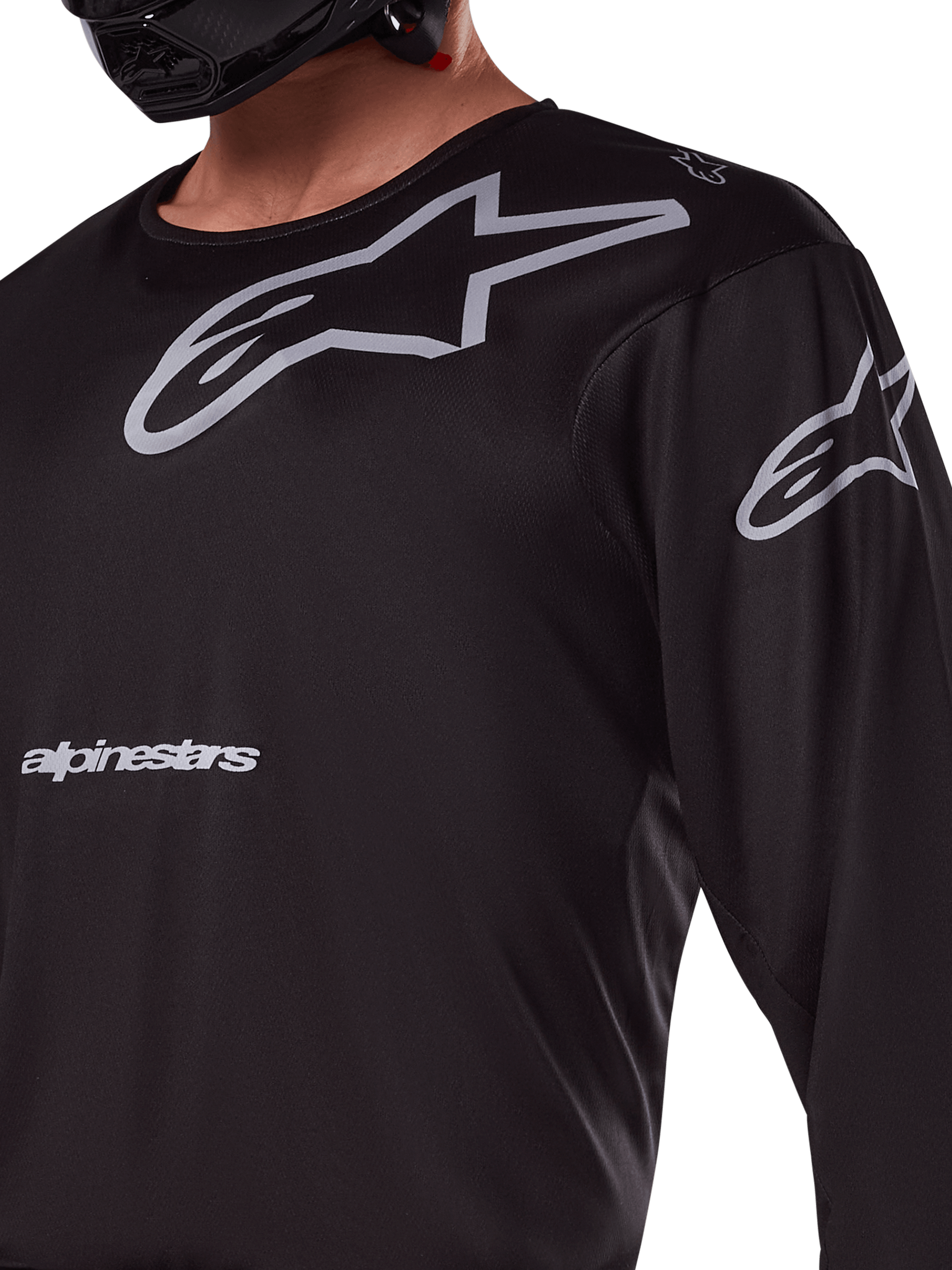 Alpinestars 2025 Racer Graphite Jersey, sort og grå, nærbillede af kører iført motocross-jersey, med grå Alpinestars-branding og A-star-logoer, teknisk poly-stofmateriale til off-road kørsel