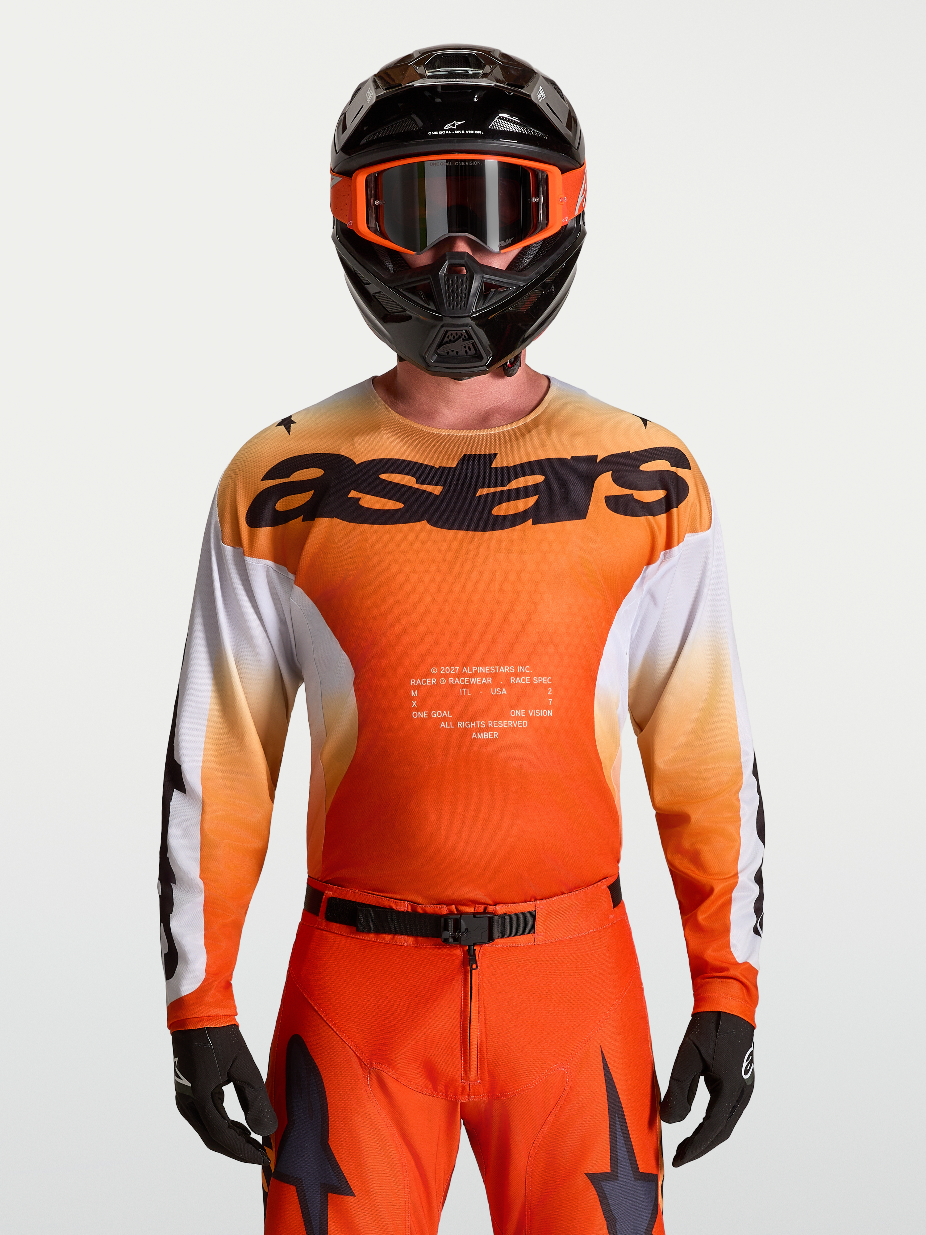 Alpinestars Racer Amber trøje, motocross racingtrøje til herrer, orange og hvid, fugttransporterende poly-stof, race fit, vist med matchende hjelm og bukser til off-road kørsel.